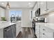 Bright kitchen featuring stainless steel appliances, white cabinets, and hardwood floors at 2132 Electric Ln, Charlotte, NC 28205
