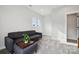 Cozy living room with plush gray sofa, ottoman, and neutral carpet at 2132 Electric Ln, Charlotte, NC 28205