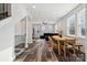 Open-concept living room with modern sofa, dining area, hardwood floors, and staircase access at 2132 Electric Ln, Charlotte, NC 28205