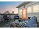 Relaxing patio featuring an egg chair, blue cushions, and an orange door at 2132 Electric Ln, Charlotte, NC 28205