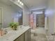Well-lit bathroom featuring a double sink vanity and shower-tub combo with neutral tile at 3308 Oscar Dr, Matthews, NC 28105