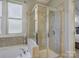 Bathroom featuring a glass-enclosed shower, a soaking tub, and neutral tile at 3308 Oscar Dr, Matthews, NC 28105