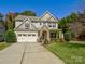 Charming two-story home boasts stone accents, a two-car garage, and a well-manicured lawn at 3308 Oscar Dr, Matthews, NC 28105