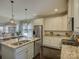 Well-lit kitchen boasts stainless appliances, granite countertops, island sink, and dark wood floors at 3308 Oscar Dr, Matthews, NC 28105