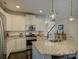 Bright kitchen with island sink, granite counters, white cabinets, and modern stainless steel appliances at 3308 Oscar Dr, Matthews, NC 28105