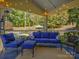 Relaxing covered patio featuring stylish blue furniture and views of the backyard at 3308 Oscar Dr, Matthews, NC 28105