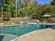 Private backyard pool with stone border, surrounded by lush greenery and lounge area at 3308 Oscar Dr, Matthews, NC 28105