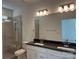 Modern bathroom with double vanity, granite countertop, and a sleek glass-enclosed shower at 407 Sunharvest Ln, Indian Trail, NC 28079