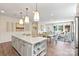 Open-concept kitchen with island, pendant lighting, and seamless flow to dining and living areas at 407 Sunharvest Ln, Indian Trail, NC 28079