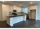 Bright kitchen featuring white cabinets, a large island, stainless steel appliances, and dark hardwood floors at 407 Sunharvest Ln, Indian Trail, NC 28079