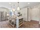 Bright kitchen with white cabinetry, stainless steel appliances and a large center island with seating at 407 Sunharvest Ln, Indian Trail, NC 28079
