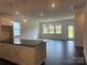 Open-concept living room featuring large windows, recessed lighting, and dark hardwood floors at 407 Sunharvest Ln, Indian Trail, NC 28079