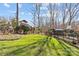 Spacious backyard featuring a playset, lush lawn, mature trees, and secure fencing at 4300 Denbigh Dr, Charlotte, NC 28226