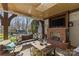 Inviting covered patio features a brick fireplace, comfortable seating, and opens to a beautifully landscaped backyard at 4300 Denbigh Dr, Charlotte, NC 28226