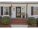 Close up of the brick staircase leading up to the front door, and sconce lighting flanking the door at 4300 Denbigh Dr, Charlotte, NC 28226