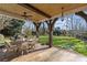 Charming outdoor dining area with seating for six, overlooking a lush green lawn and mature landscaping at 4300 Denbigh Dr, Charlotte, NC 28226