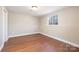 Finished basement room with hardwood floors, neutral paint, and a window at 4836 Cheviot Rd, Charlotte, NC 28269