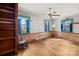The room has a rustic aesthetic with exposed wood paneling, original wood floors, and large windows with blue curtains at 4928 Tuckaseegee Rd, Charlotte, NC 28208