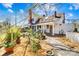 Side view of a charming white two-story home, featuring a front porch and beautifully landscaped yard at 4928 Tuckaseegee Rd, Charlotte, NC 28208