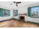 Charming living room features a vintage fireplace, hardwood floors, and natural light from shuttered windows at 4928 Tuckaseegee Rd, Charlotte, NC 28208