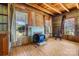 Cozy living room with wood paneled walls, multiple windows, and a blue fireplace at 4928 Tuckaseegee Rd, Charlotte, NC 28208