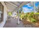 Inviting covered porch featuring brick flooring, white columns, and scenic views of the landscaped yard at 4928 Tuckaseegee Rd, Charlotte, NC 28208