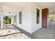 Spacious covered front porch with brick flooring and classic white wood trim at 4928 Tuckaseegee Rd, Charlotte, NC 28208