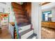 Wooden staircase with natural light and rustic charm, leading to an upper level with unique features at 4928 Tuckaseegee Rd, Charlotte, NC 28208