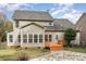 View of the back of the house with a deck, stone path, neutral siding, and black roof at 5672 Wrenfield Ct, Charlotte, NC 28277