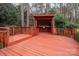 Outdoor deck with a hot tub under a covered pavilion, surrounded by lush greenery and trees at 5672 Wrenfield Ct, Charlotte, NC 28277