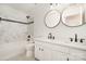 Modern bathroom with double sinks, elegant mirrors, and a beautifully tiled shower, perfect for everyday convenience at 5672 Wrenfield Ct, Charlotte, NC 28277