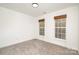 Bright bedroom featuring neutral carpet, two windows with natural light, and fresh white walls at 5672 Wrenfield Ct, Charlotte, NC 28277