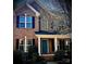 Beautiful brick home featuring a well-kept yard, flowering tree, and inviting front porch at 5672 Wrenfield Ct, Charlotte, NC 28277