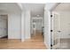 Hallway with hardwood flooring, trim details, and multiple doorways leading to various rooms at 5672 Wrenfield Ct, Charlotte, NC 28277