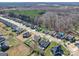 This aerial view displays houses in a tranquil neighborhood with a swimming pool surrounded by lush greenery at 572 Church St, Locust, NC 28097
