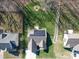 This aerial view showcases a home with solar panels, lush greenery, and a fire pit in a serene backyard setting at 572 Church St, Locust, NC 28097