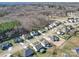 This aerial view displays houses in a tranquil neighborhood surrounded by lush greenery, offering a peaceful living environment at 572 Church St, Locust, NC 28097