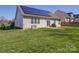 Backyard with solar panels, sliding glass doors, and a well-maintained lawn at 572 Church St, Locust, NC 28097