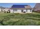 Backyard with solar panels, sliding glass doors, and a well-maintained lawn at 572 Church St, Locust, NC 28097
