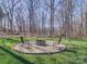 Backyard fire pit with chairs and a wooded backdrop at 572 Church St, Locust, NC 28097