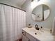 Clean bathroom with a round mirror, simple vanity, and classic shower curtain at 572 Church St, Locust, NC 28097