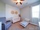 This bedroom features a cozy crib, a toddler bed, and a comfortable gray chair with a ceiling fan at 572 Church St, Locust, NC 28097