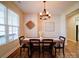 Bright dining room with a wooden table, modern lighting, and large windows at 572 Church St, Locust, NC 28097