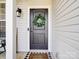Close up of a dark front door with a wreath and 'Welcome Friends' doormat at 572 Church St, Locust, NC 28097
