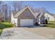 Charming brick home with well-maintained lawn, two-car garage, and inviting front porch at 572 Church St, Locust, NC 28097