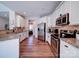Open kitchen boasts white cabinets, stainless appliances, granite counters, and access to dining area at 572 Church St, Locust, NC 28097