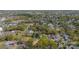 Expansive aerial view of the neighborhood with mature trees, houses, and local amenities under a clear blue sky at 574 Reid St, Belmont, NC 28012