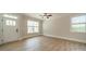 Bright bedroom featuring wood flooring, a ceiling fan, and two large windows for natural light at 574 Reid St, Belmont, NC 28012