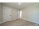 Neutral bedroom featuring two bright white doors and neutral walls and carpeting at 574 Reid St, Belmont, NC 28012