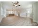 Spacious open-concept living room with wood floors, a ceiling fan, and seamless flow to the modern kitchen at 574 Reid St, Belmont, NC 28012